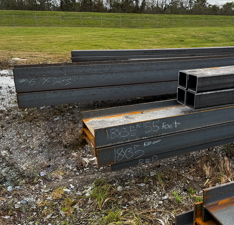 Structural steel beams with identification markings staged for fabrication and material traceability in offshore construction.